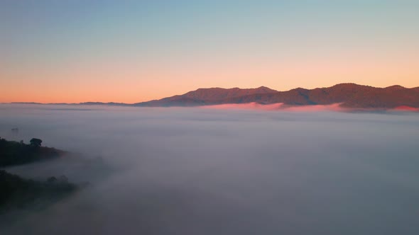 A sea of clouds above the valley and the mountains in the background