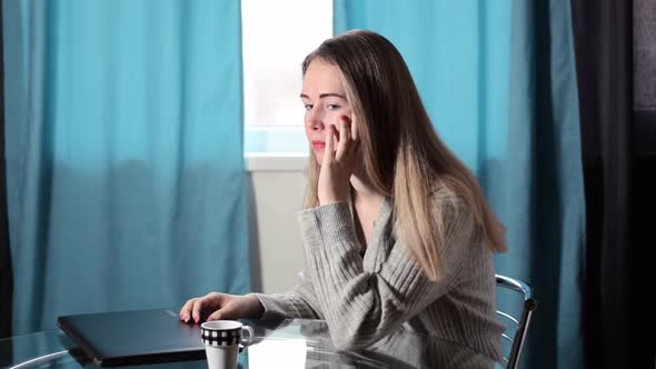 Worried young woman is closing the laptop looking sad