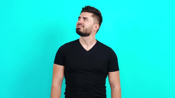 Young Caucasian Man in a Black T-shirt Looking Around Puzzled and Finally Looking Into the Room.