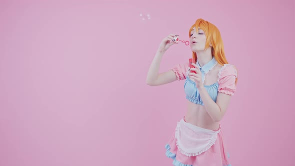 European Cover Girl Blows Big Bubbles One By One Medium Long Studio Shot Pink Background