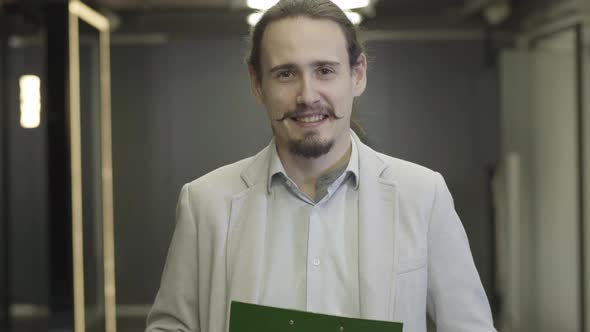 Close-up of Happy Caucasian Man with Brown Eyes and Black Hair Looking at Camera and Smiling. Male