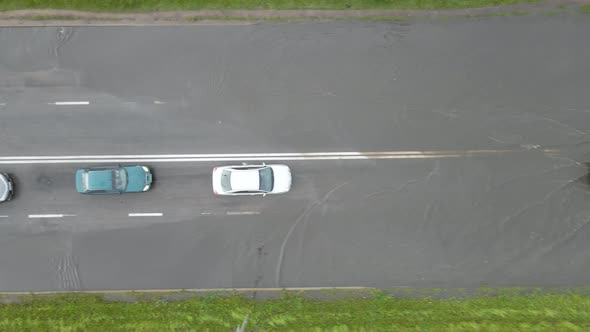 Aerial view of city traffic with cars driving on flooded street after heavy rain. Problems