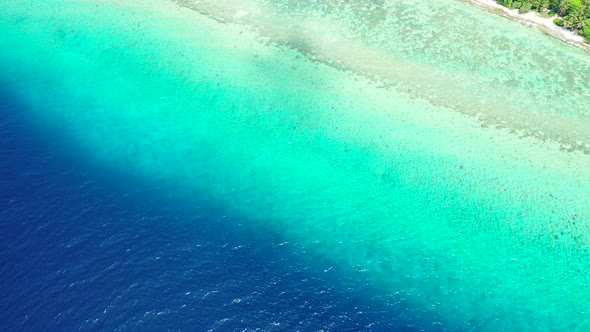 Wide aerial travel shot of a summer white paradise sand beach and turquoise sea background in colour