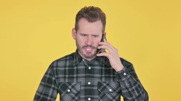 Portrait of Angry Middle Aged Man Talking on Smartphone