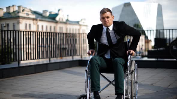 Handicapped Businessman Trying To Get Up From Wheelchair Outdoor