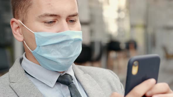 Freelance Businessman in Protective Mask Using His Phone