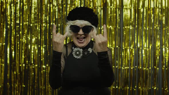 Excited Positive Senior Woman Showing Rock and Roll Gesture and Sincerely Smiling, Showing Tongue