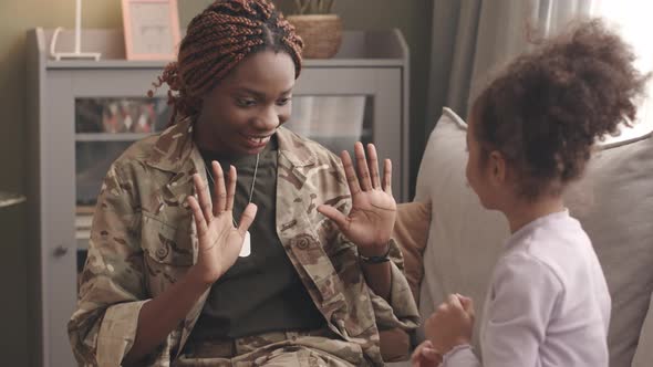 Mother in Military Uniform and Daughter Playing Patty Cake