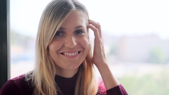 Portrait of smiling businesswoman at window