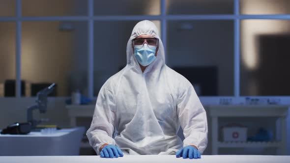 Caucasian male medical worker wearing protective clothing and mask using virtual digital interface i
