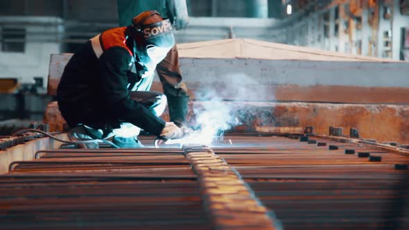 Worker Welding Metal Construction in Protective Mask at Steel Factory