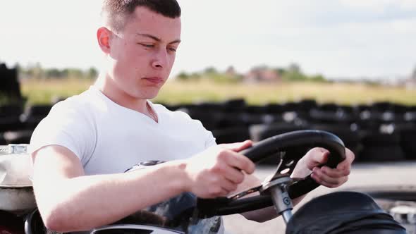 Attractive Man Sititng in a Gocart on the Track