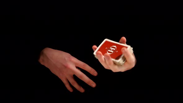 Magician Shows His Trick with Playing Cards on Black Background