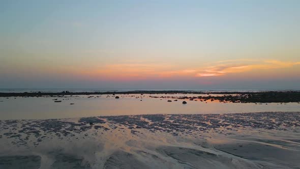 Tilt down shot of a beautiful sunset at the sea beach in Saint Martin Island, Bangladesh. Rocky cora