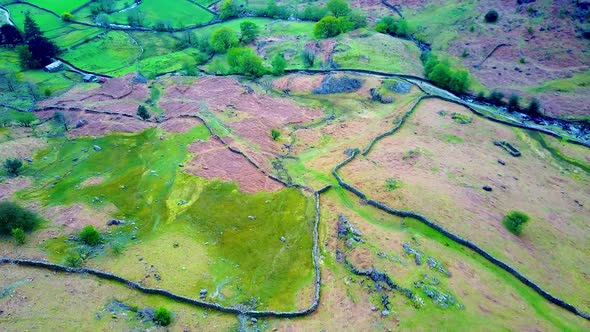 Aerial shot over grass fields in the Lake district Northern England