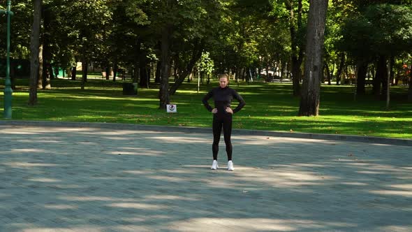 Sporty Woman Warming Up Feet Before Jogging in Park