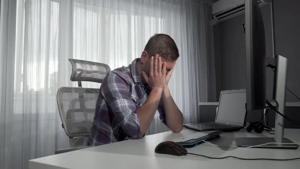 Upset Male Freelancer Sitting in Front of His Computers