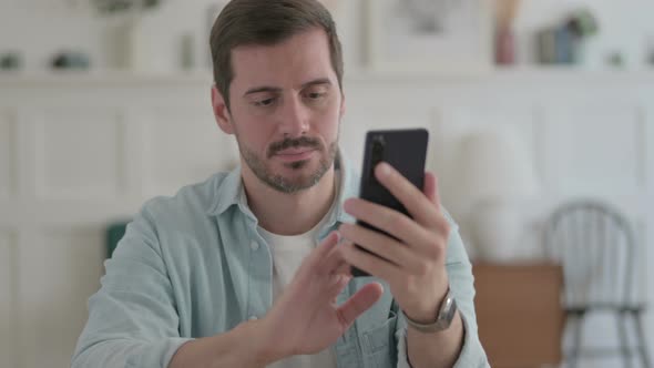 Young Man Browsing Internet on Smartphone