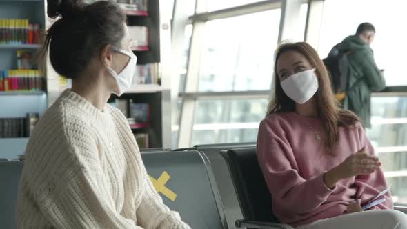 Prevention From Coronavirus - Social Distancing. Two Women Tourists in Medical Mask Sitting in