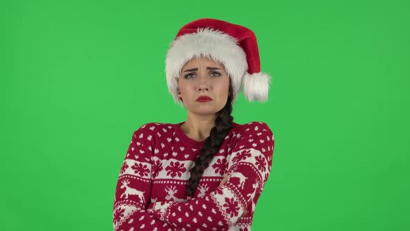 Portrait of Sweety Girl in Santa Claus Hat Is Very Offended and Looking Away. Green Screen