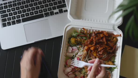 Top View of Woman Working on Laptop and Eating Food in Box