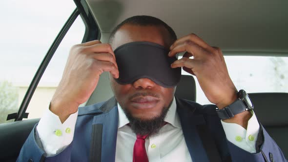 Tired Business Person Putting on Sleep Mask to Nap in Car