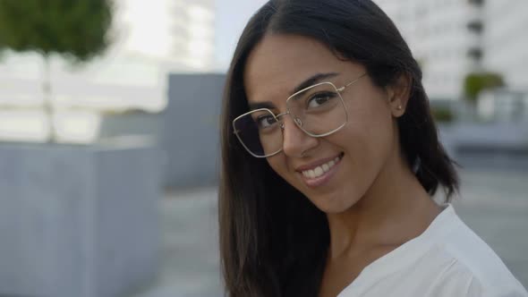 Beautiful hispanic woman in Eyeglasses Looking at Camera in City