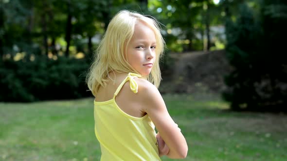 Little Cute Girl Looks Around in the Park - Shot on Back