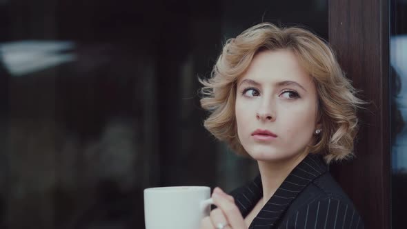 Portrait of Beautiful Lady Thinks and Drinks a Cup of Tea at House