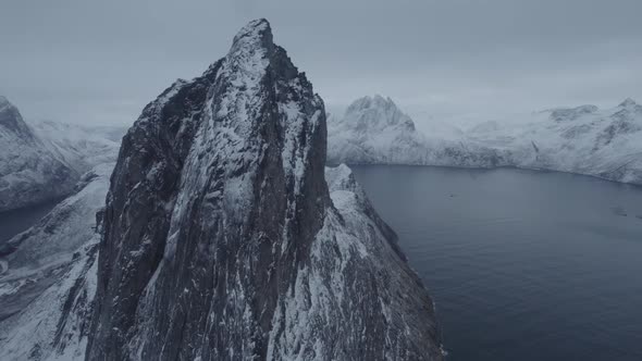 Aerial view close around the Segla mountain, gloomy winter day in Senja, North Norway - circling, dr