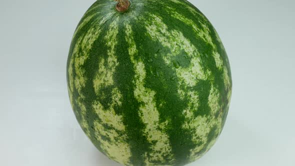 Watermelon Covered In Drops Of Water On A White Surface