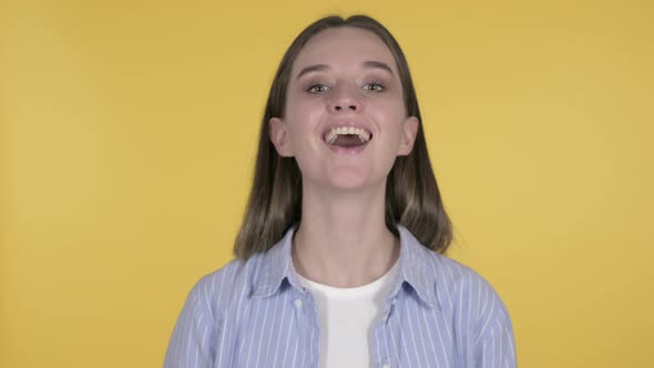 Yes, Young Woman Shaking Head To Accept on Yellow Background
