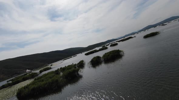 Breathtaking Scenery From a Drone's FPV Along the Lake Bright Blue Skies in the Background a Sunny