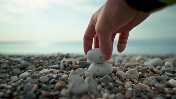Closeup Slow Motion Man's Hand Tries to Build a Stone Piramida with Pebble on Sea Beach