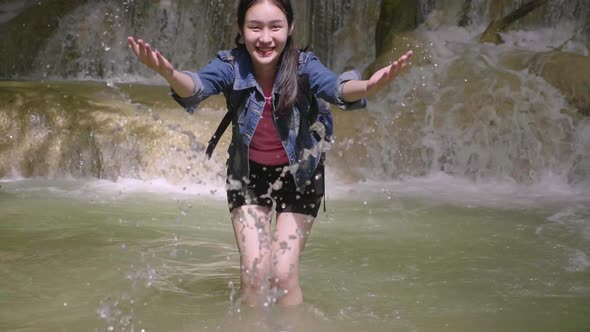 Young Girl Splashing The Water At Waterfall