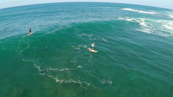 Aerial view of a man sup stand-up paddleboard surfing in Hawaii