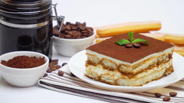 Tiramisu Portion, Coffee Mill Grinder, Savoiardi Cookies and Cup of Coffee on White Background