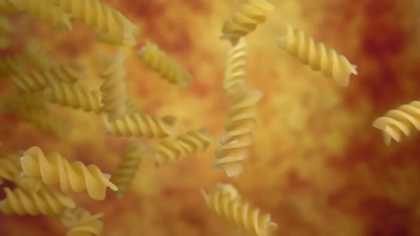 Closeup of the Pasta Fusilli Falling Diagonally on a Yellow Ochre Background