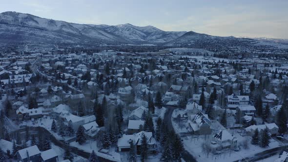 Beautiful aerial drone shot taking houses and roads covered with snow over Park City, Utah,USA in a