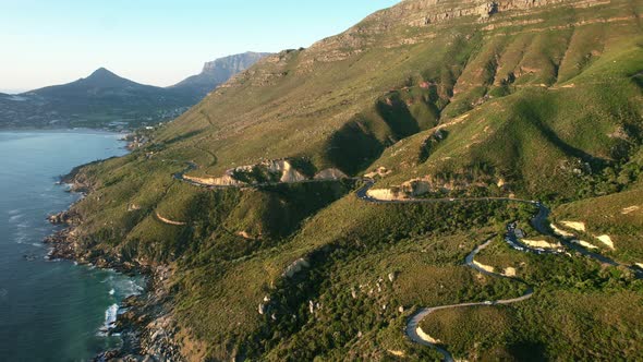 winding mountain roads on coast of Chapmans Peak in Cape Town at sunset, aerial