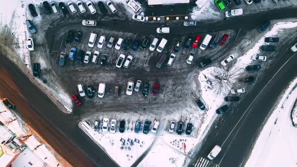 Aerial Top View of Small Supermarket Parking Lot with Cars at Winter Evening