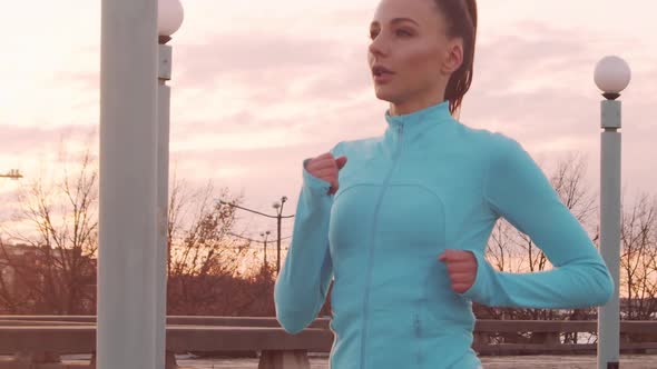 Young, beautiful and sporty woman having evening training outdoor.