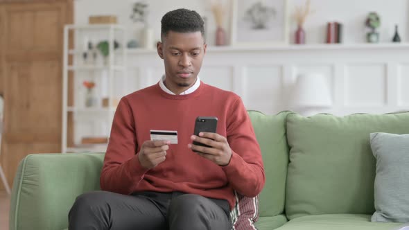 African Man making Online Payment on Smartphone