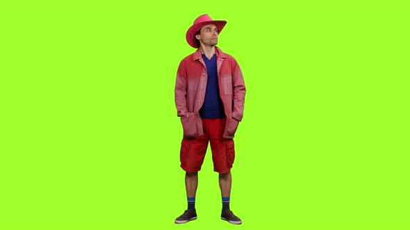 Handsome Man in Red Jacket and Cowboy Hat on Green Background