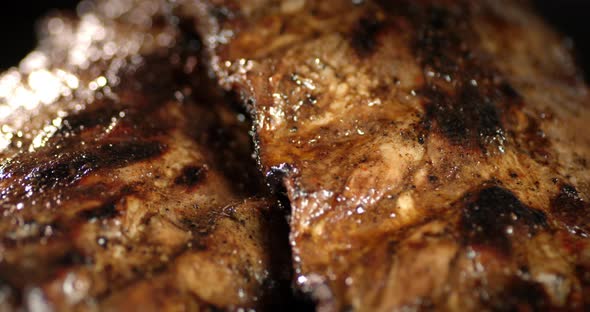 The Appetizing Ribs on the Grill Rotate Slowly. 