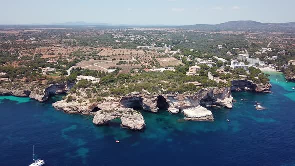 Aerial: Natural arch nearby Cala Santanyi in Mallorca, Spain