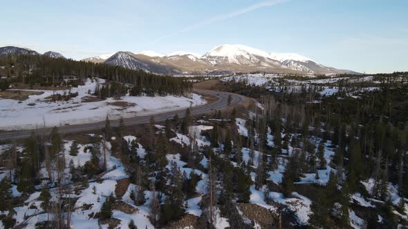 4K drone video reveal of cars driving in Rocky Mountains during winter in Colorado.