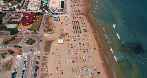 Drone Flies Hight Overlooking La Mata Beach Full of People on Summer Day