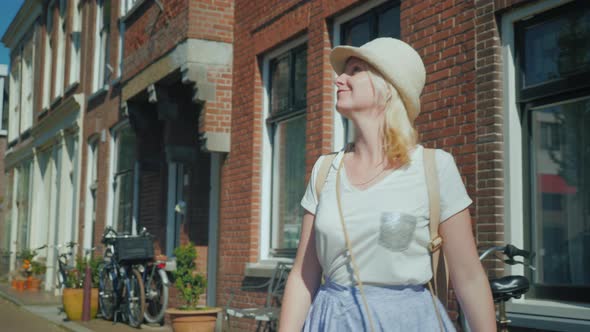 A Woman Emotionally Enjoys Walking Along the Street of the Old City in Europe