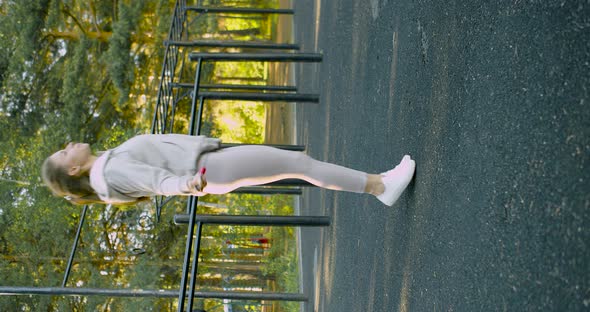 Vertical Video of a Woman in Sport Outfit Jumping Rope on a Sports Field in the Park